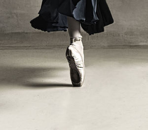 Low section of ballet dancer dancing on floor