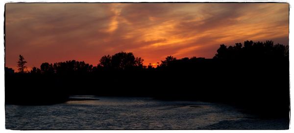 Scenic view of silhouette trees against sky at sunset