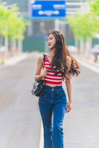 Beautiful young woman walking on street