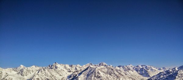 Idyllic shot of snowcapped mountains against clear blue sky