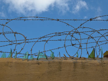 Barbed wire fence against sky