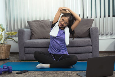 Woman sitting on sofa at home