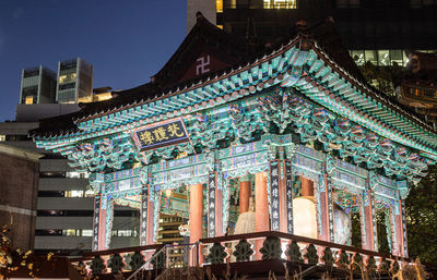 Low angle view of illuminated building against sky