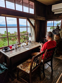 Rear view of woman sitting on chair at home