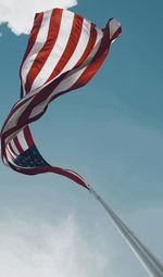 Low angle view of american flag against sky on sunny day