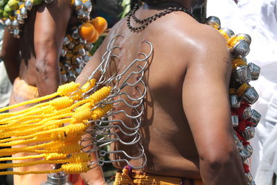 Close-up of shirtless man with flowers