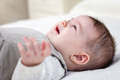 Portrait of cute baby lying on bed at home