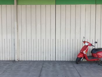 Motor scooter parked by wall