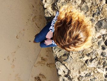 Directly above shot of girl sitting on surrounding wall