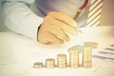 Midsection of businessman analyzing data on desk in office