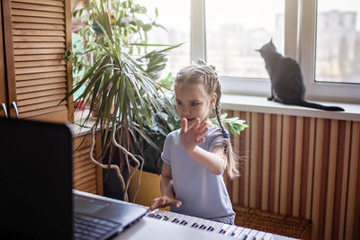 Cute girl playing piano at home