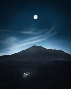 Scenic view of mountains against sky at night