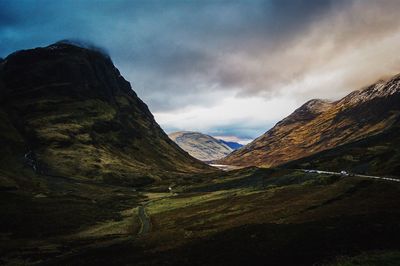 Scenic view of mountains against cloudy sky