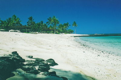 Scenic view of beach against clear blue sky