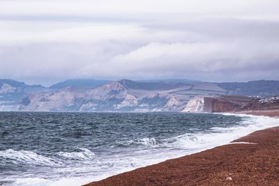 Scenic view of sea and mountains against sky