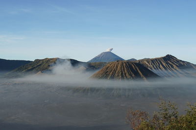 Smoke emitting from volcanic mountain against sky