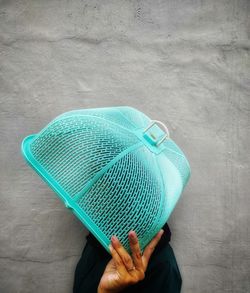 Close-up of woman holding basket standing by wall outdoors