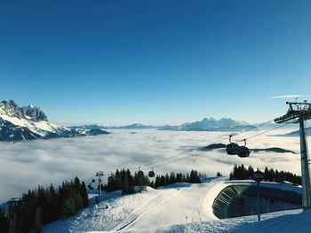 Scenic view of snow covered mountains against clear blue sky