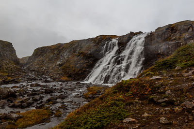 Scenic view of waterfall against sky