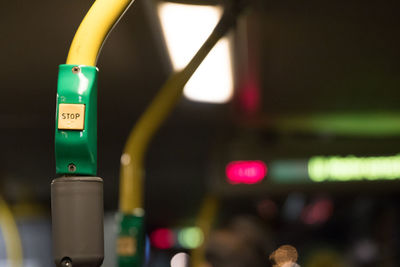 Close-up of stop push button on pole in illuminated bus