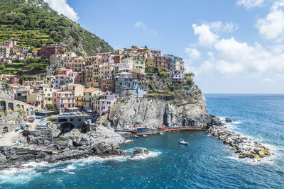 Scenic view of sea by buildings against sky