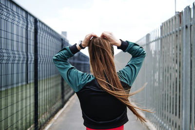 Rear view of woman standing in front of building