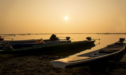 Boats sailing on sea against clear sky during sunset