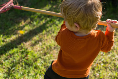 Rear view of boy holding camera