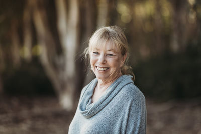 Portrait of smiling senior adult woman smiling in forest