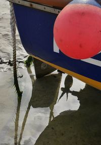 Reflection of boat moored in lake