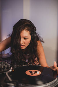 Close-up of fashionable young woman playing music at home