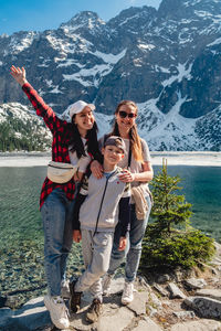 Rear view of woman using mobile phone while standing against mountain