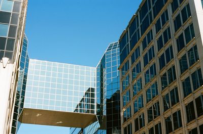 Low angle view of modern building against clear blue sky