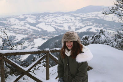 Portrait of smiling young woman on snowcapped mountains