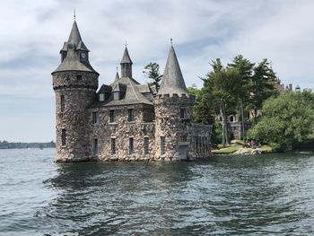 Historic building by river against sky