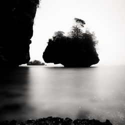 Scenic view of rock in sea against clear sky