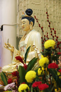 Statue with fresh flowers in front