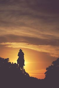 Silhouette men against sky during sunset