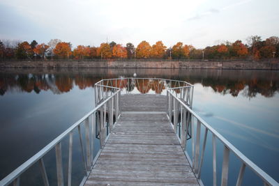 Pier over lake against sky during autumn