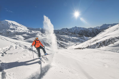 Rear view of man walking on snow covered mountain