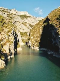 Scenic view of river amidst mountains against sky