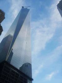 Low angle view of modern building against cloudy sky