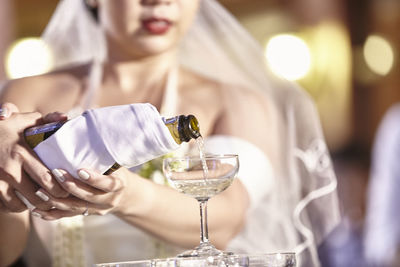 Close-up of bride pouring champagne