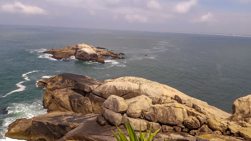 Rocks on sea shore against sky