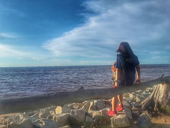 Woman on beach against sky