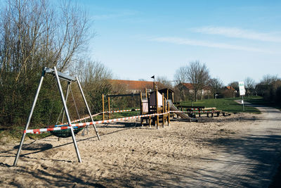 View of a closed playground in park against sky