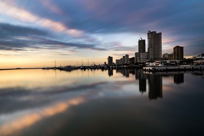 Scenic view of sea and buildings against sky during sunset