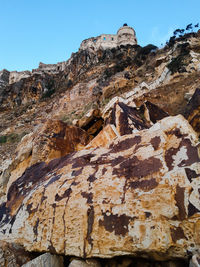 Low angle view of rock formations against sky