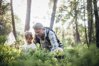 Father and daughter collection garbage in forest