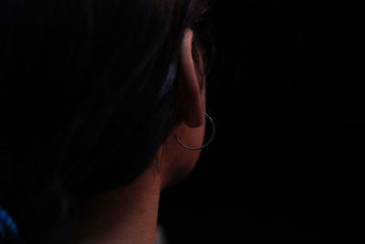 Cropped image of woman against black background